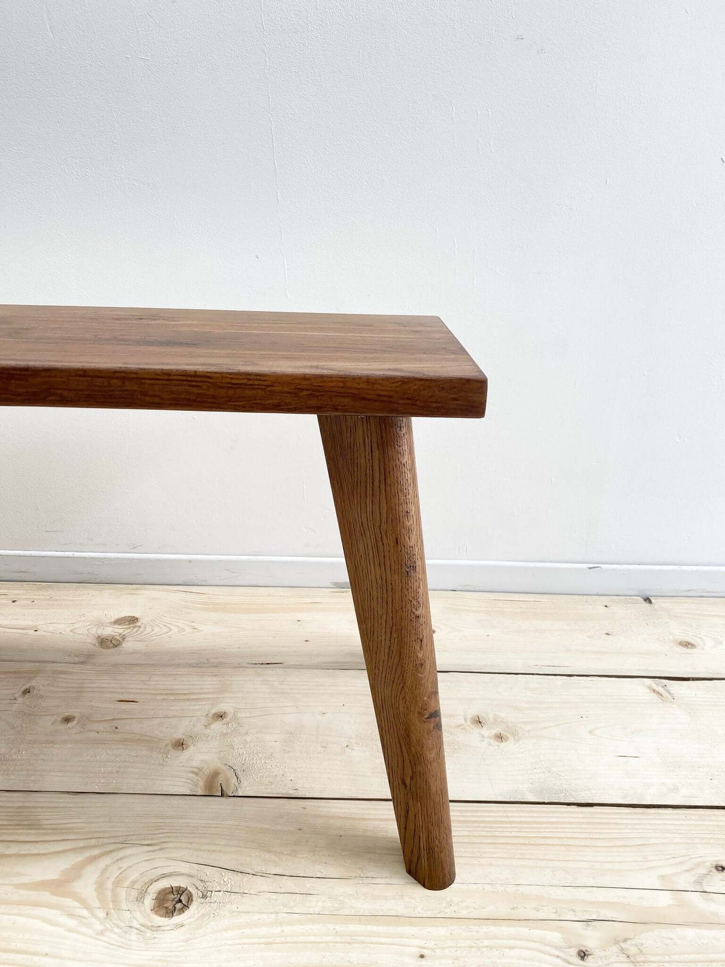 Hardwood bench seat with solid wood legs.