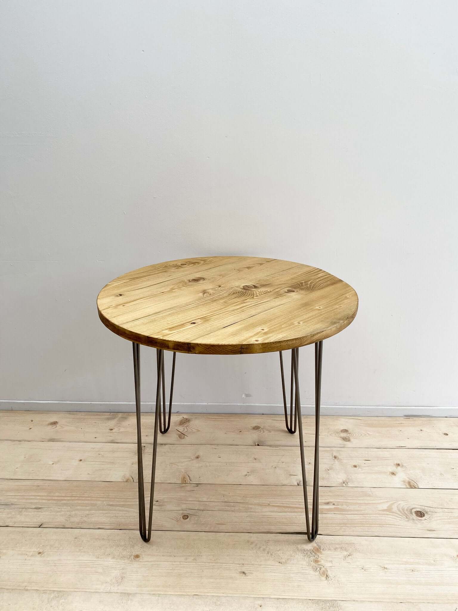 Reclaimed wood circle dining table with hairpin legs.